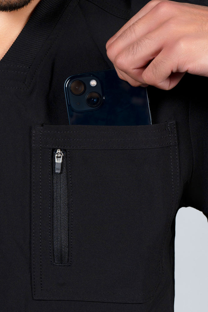 Men's Performance Zip Scrub Top in Black closeup on model putting phone into pocket