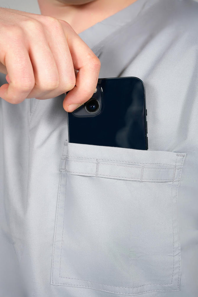 Men's 4-Pocket Scrub Top in Light Grey model putting phone into top pocket