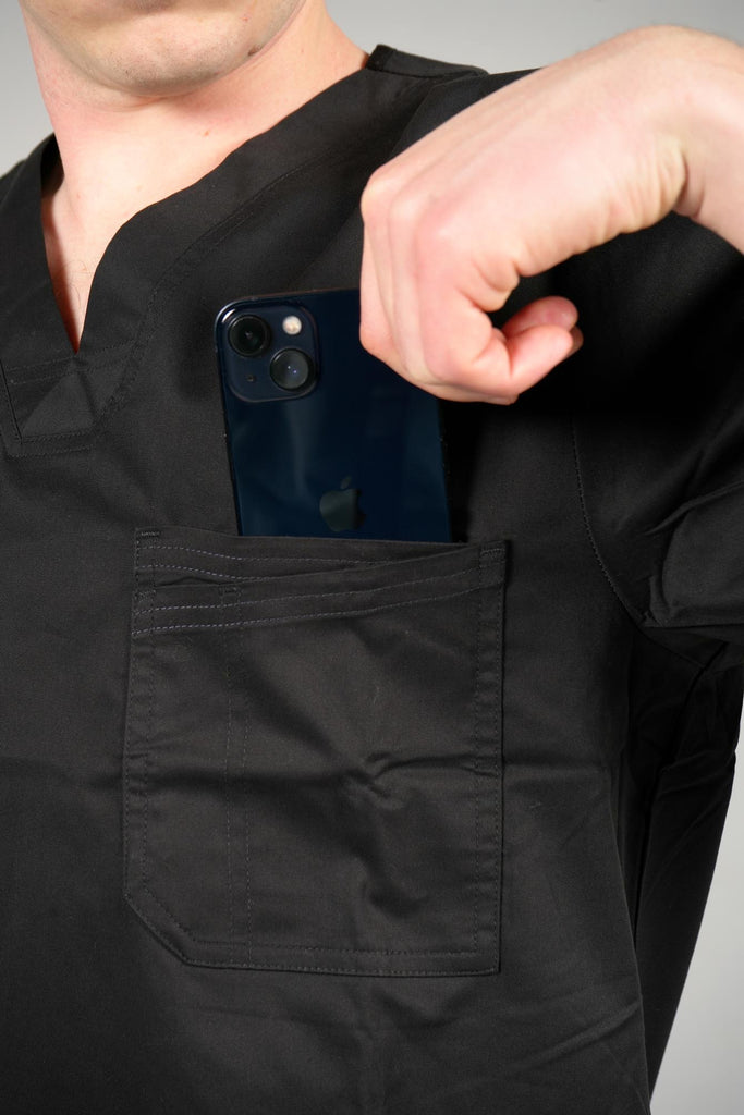 Men's 2-Pocket V-Neck Scrub Top in Black model putting phone in pocket