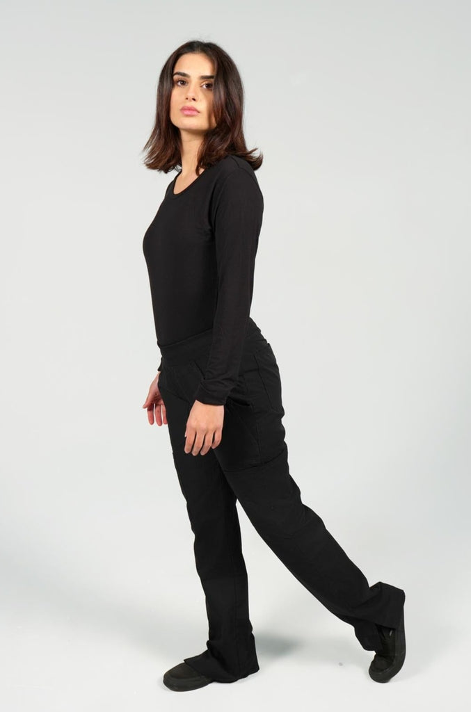 Women's 6-Pocket Elastic Scrub Pant in Black sideview on model wearing black underscrub top