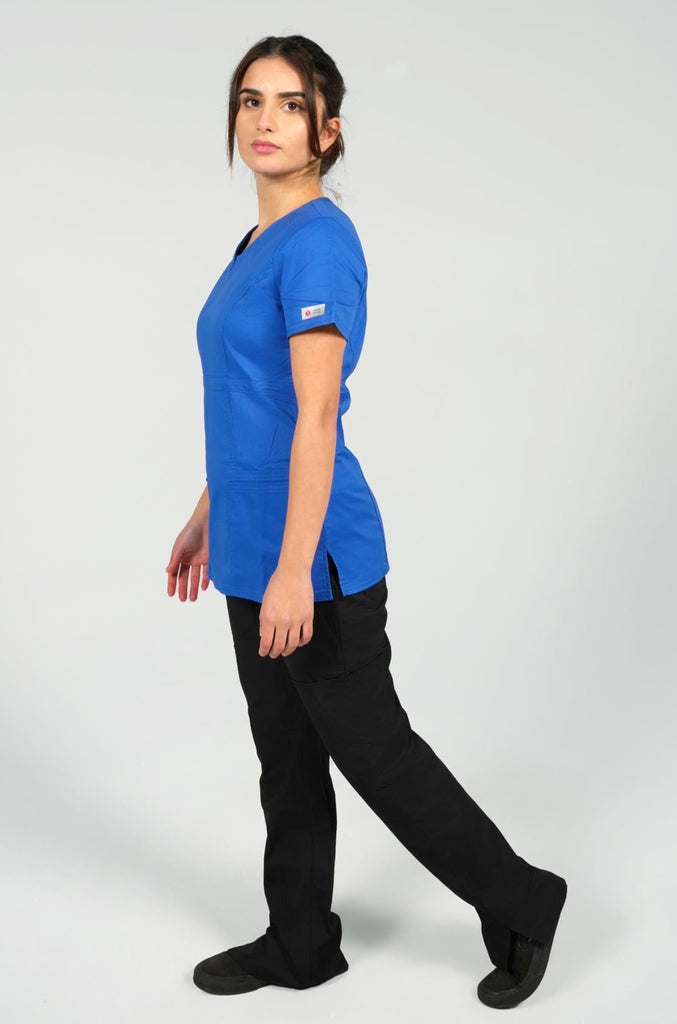 Women's 4-Pocket Curved V-Neck Scrub Top in Royal Blue sideview on model wearing black scrub pants
