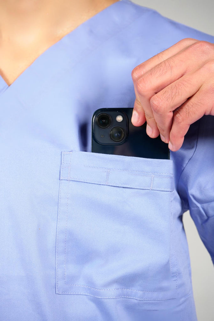 Men's 4-Pocket Scrub Top in Periwinkle model putting phone into top pocket