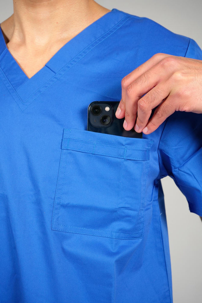Men's 4-Pocket Scrub Top in Royal Blue model putting phone into top pocket