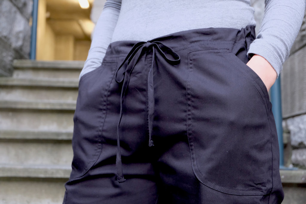 Women's 4-Pocket Scrub Pants in black closeup on drawstring, pockets and waistband on model