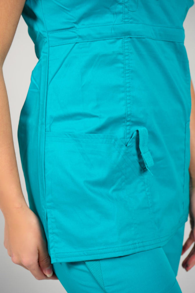 Women's 4-Pocket Curved V-Neck Scrub Top in Teal closeup on pocket with utility loop