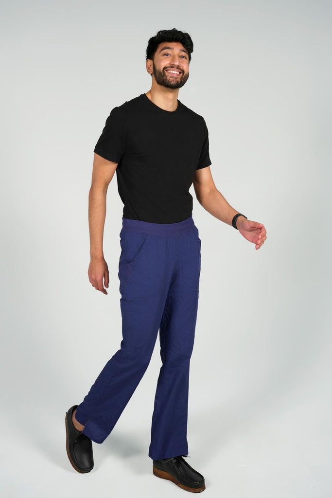 Men's 6-Pocket Elastic Scrub Pant in Navy side view on model wearing black top