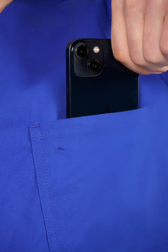 Men's 3-Pocket Scrub Top in Indigo closeup on model putting phone into pocket