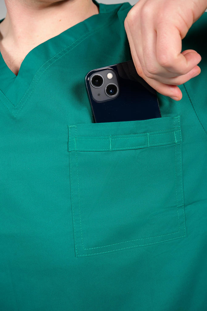 Men's 4-Pocket Scrub Top in Forest Green model putting phone into top pocket