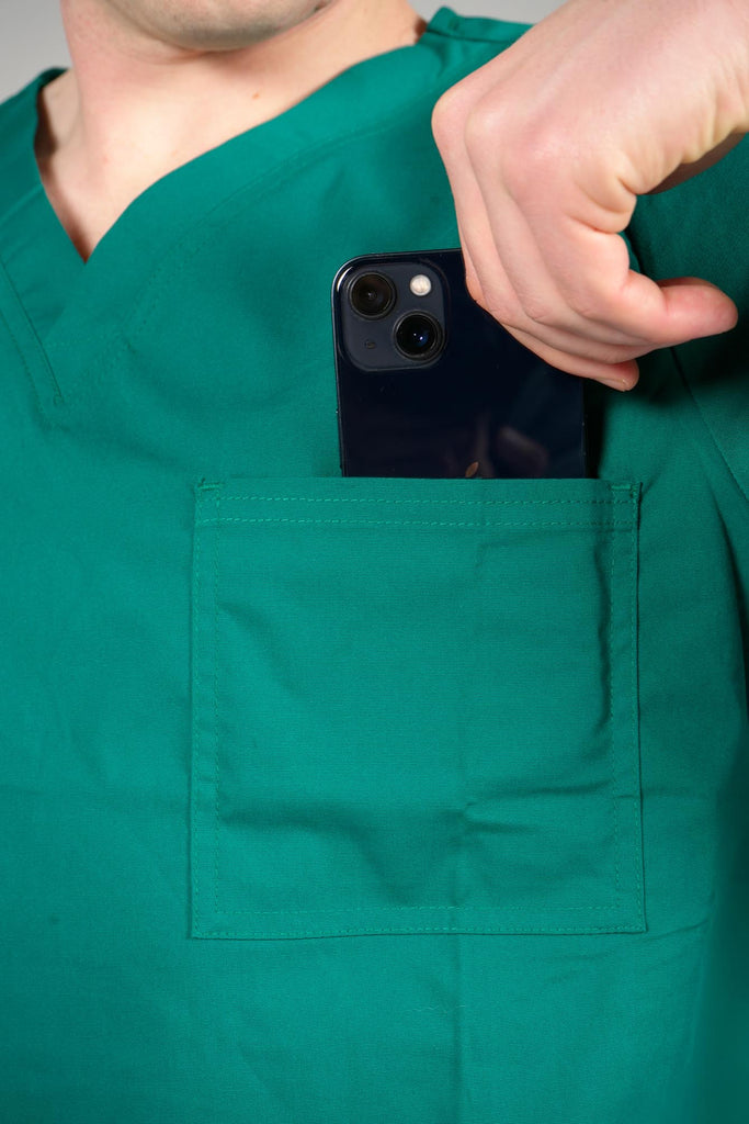 Men's 3-Pocket Scrub Top in Forest Green closeup on model putting phone into pocket