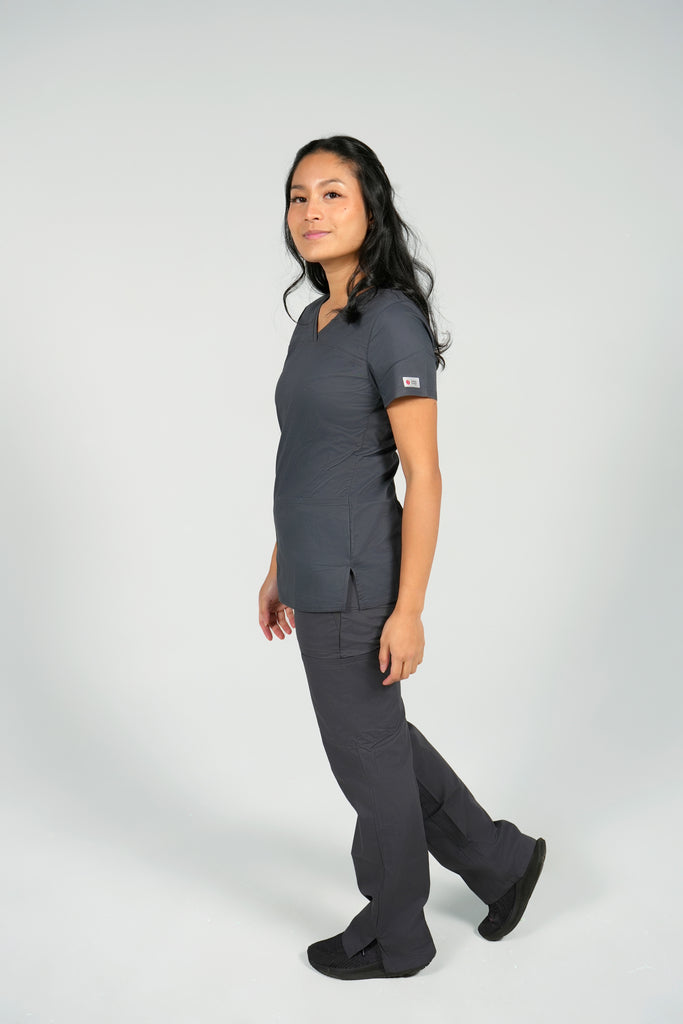 Women's Tailored 4-Pocket V-Neck Scrub Top in Charcoal side view on model wearing matching charcoal scrub pants