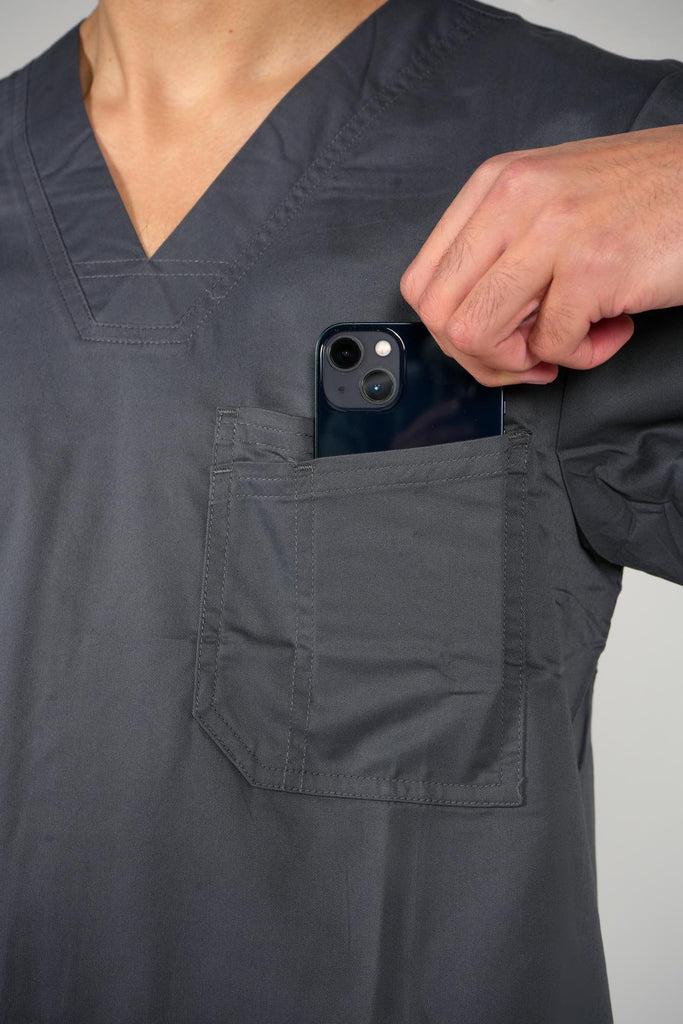 Men's 2-Pocket V-Neck Scrub Top in Charcoal model putting phone into top chest pocket