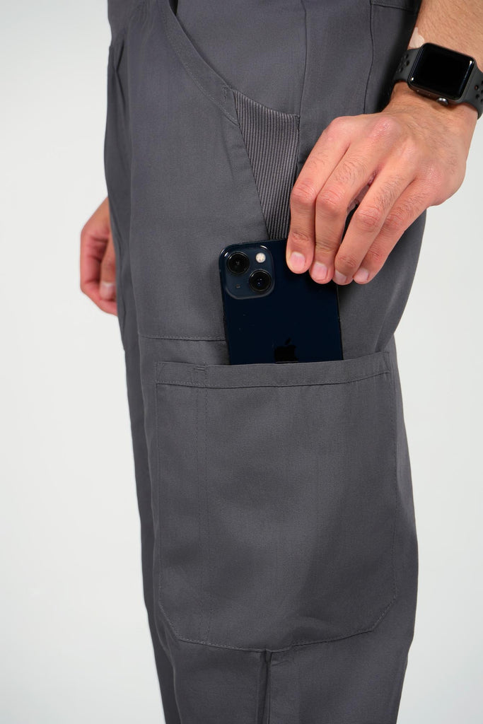 Men's 6-Pocket Elastic Scrub Pant in Charcoal closeup on model putting phone into pocket