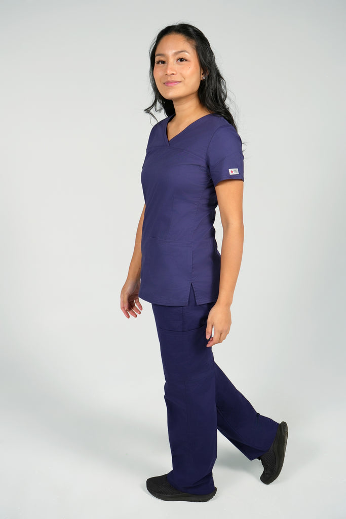 Women's Tailored 4-Pocket V-Neck Scrub Top in Navy side view on model wearing navy scrub pants