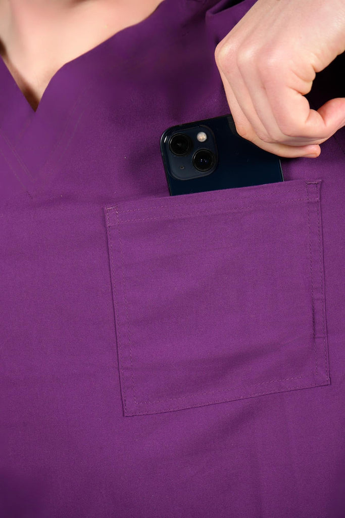 Men's 3-Pocket Scrub Top in Eggplant closeup on model putting phone into pocket