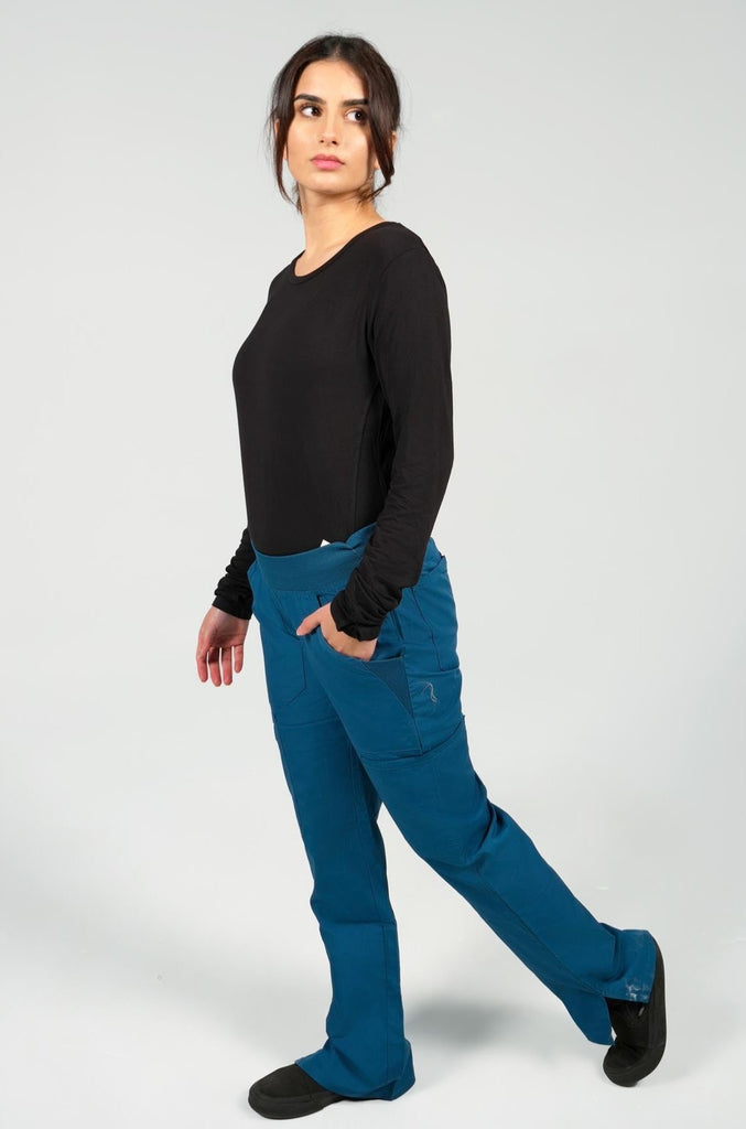 Women's 6-Pocket Elastic Scrub Pant in Caribbean side view on model wearing black underscrub top