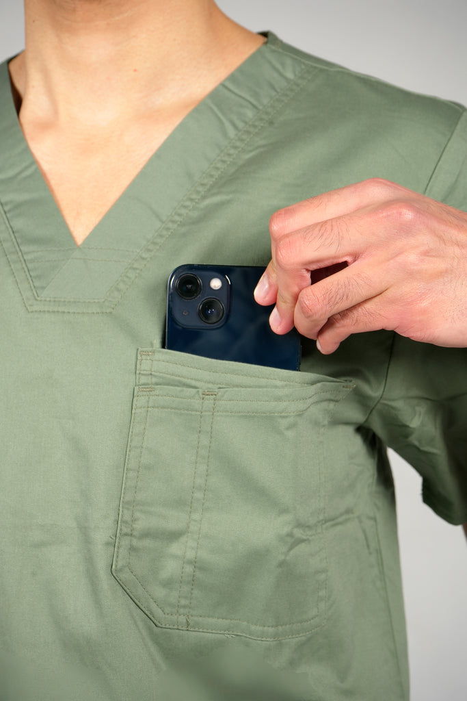 Men’s 2-Pocket V-Neck Scrub Top in Olive model putting phone into pocket