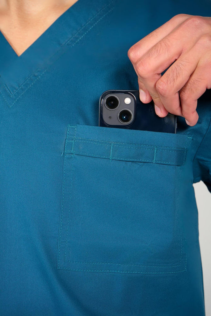 Men's 4-Pocket Scrub Top in Caribbean model putting phone into top pocket