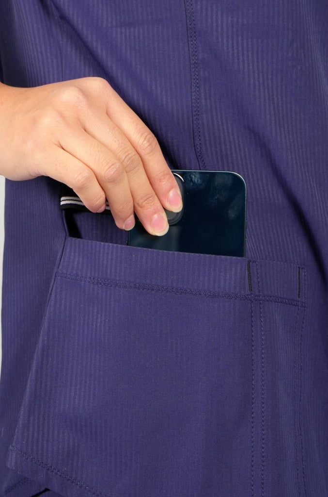 Women's Active Striped Scrub Top in navy model putting phone into pocket