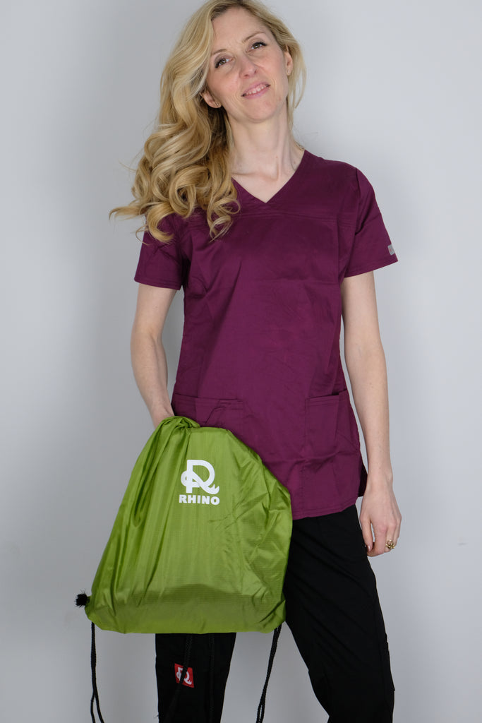 Women's Tailored 4-Pocket V-Neck Scrub Top in Wine on model wearing black scrub pants and holding Rhino Scrubs bag