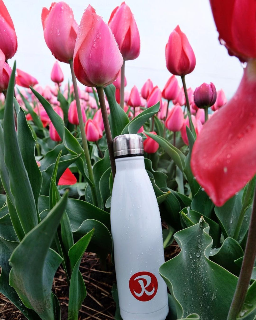 Rhino stainless steel white Water Bottle in field of tulips