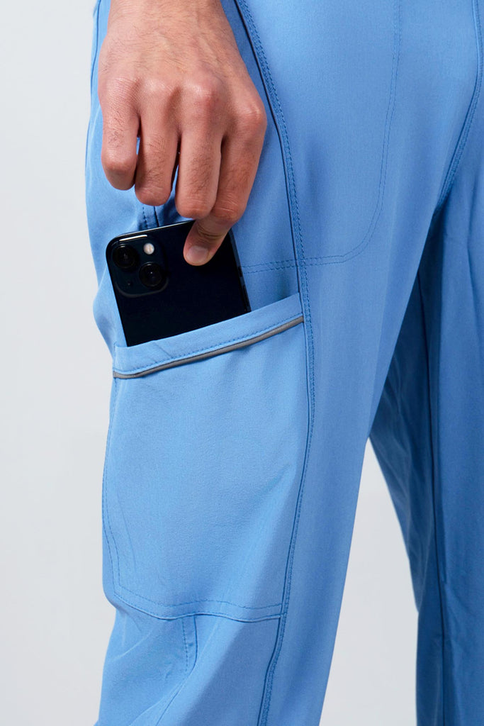 Men's Performance Scrub Jogger in shade periwinkle with model putting phone into pocket