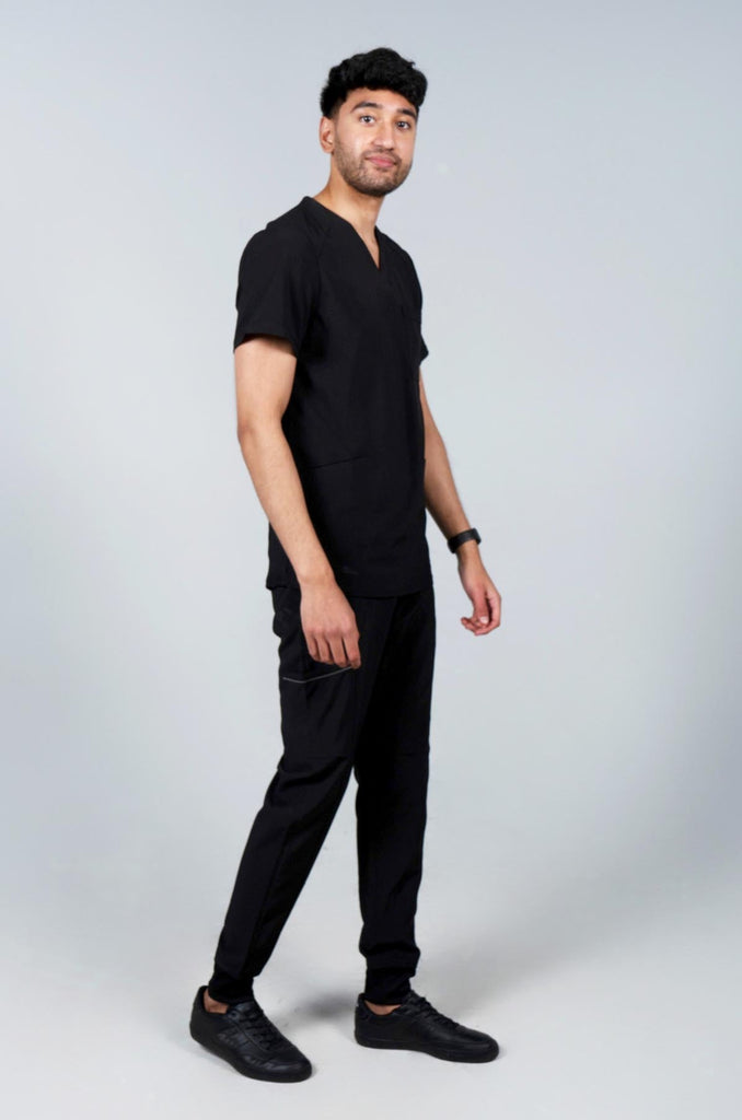 Men's Performance Scrub Top in black side view on model wearing matching black jogger scrub pants