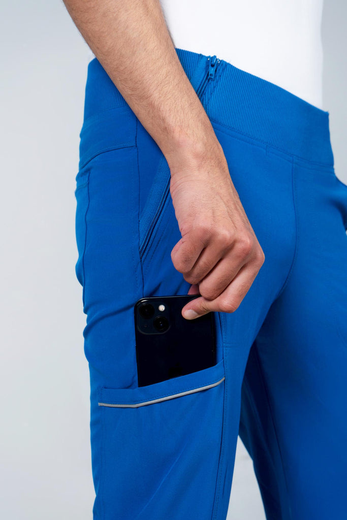 Men's Performance Scrub Jogger in shade royal blue with model putting phone into pocket