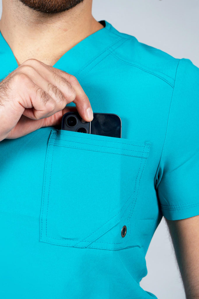 Men's Performance Scrub Top in Teal model putting phone into pocket