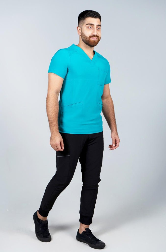 Men's Performance Scrub Top in Teal front view on model wearing black performance jogger scrub pants